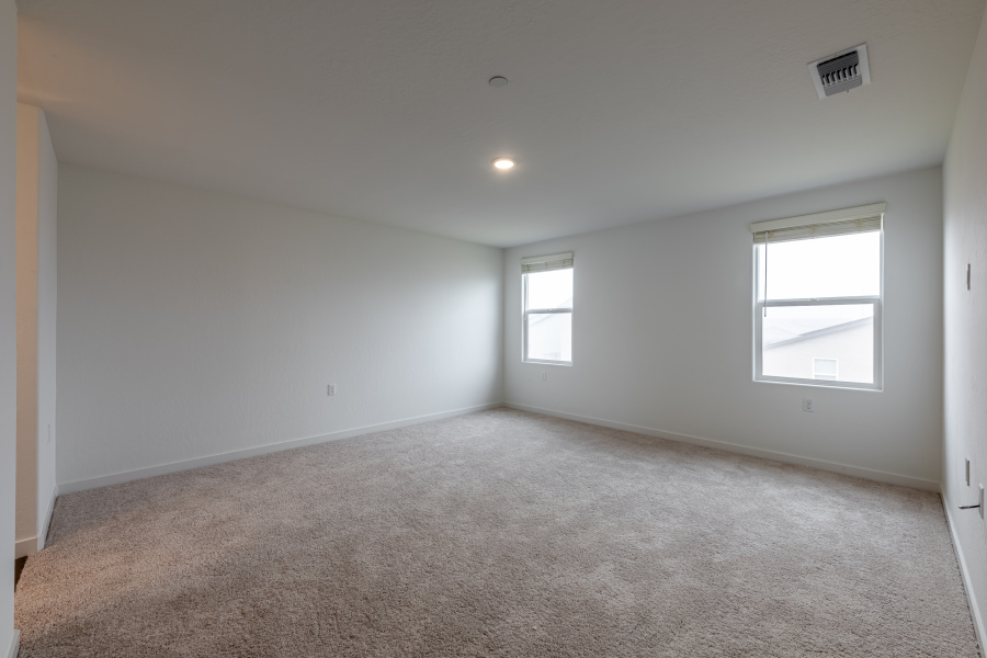 A room with a carpet and windows.