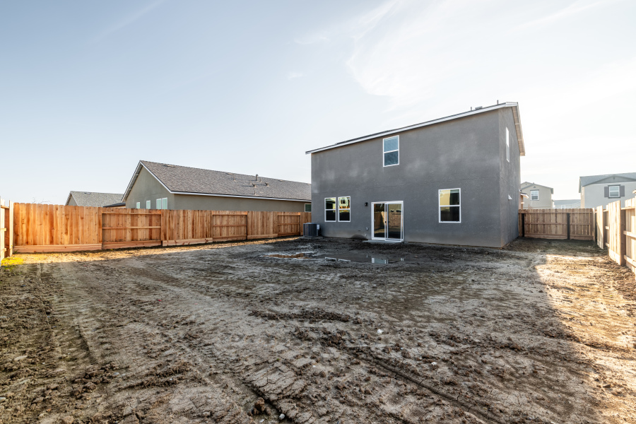 A dirt road with buildings on the side.