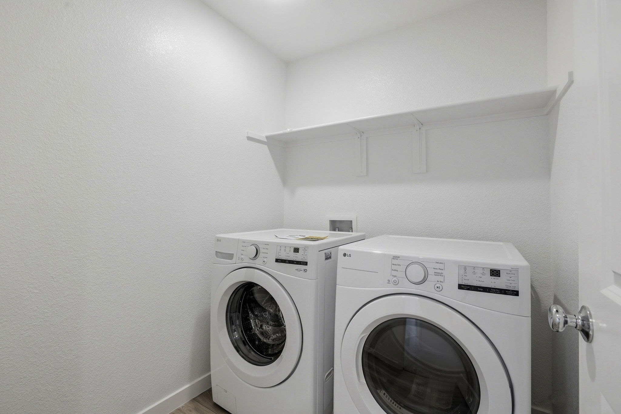 A white laundry room with a washer and dryer.