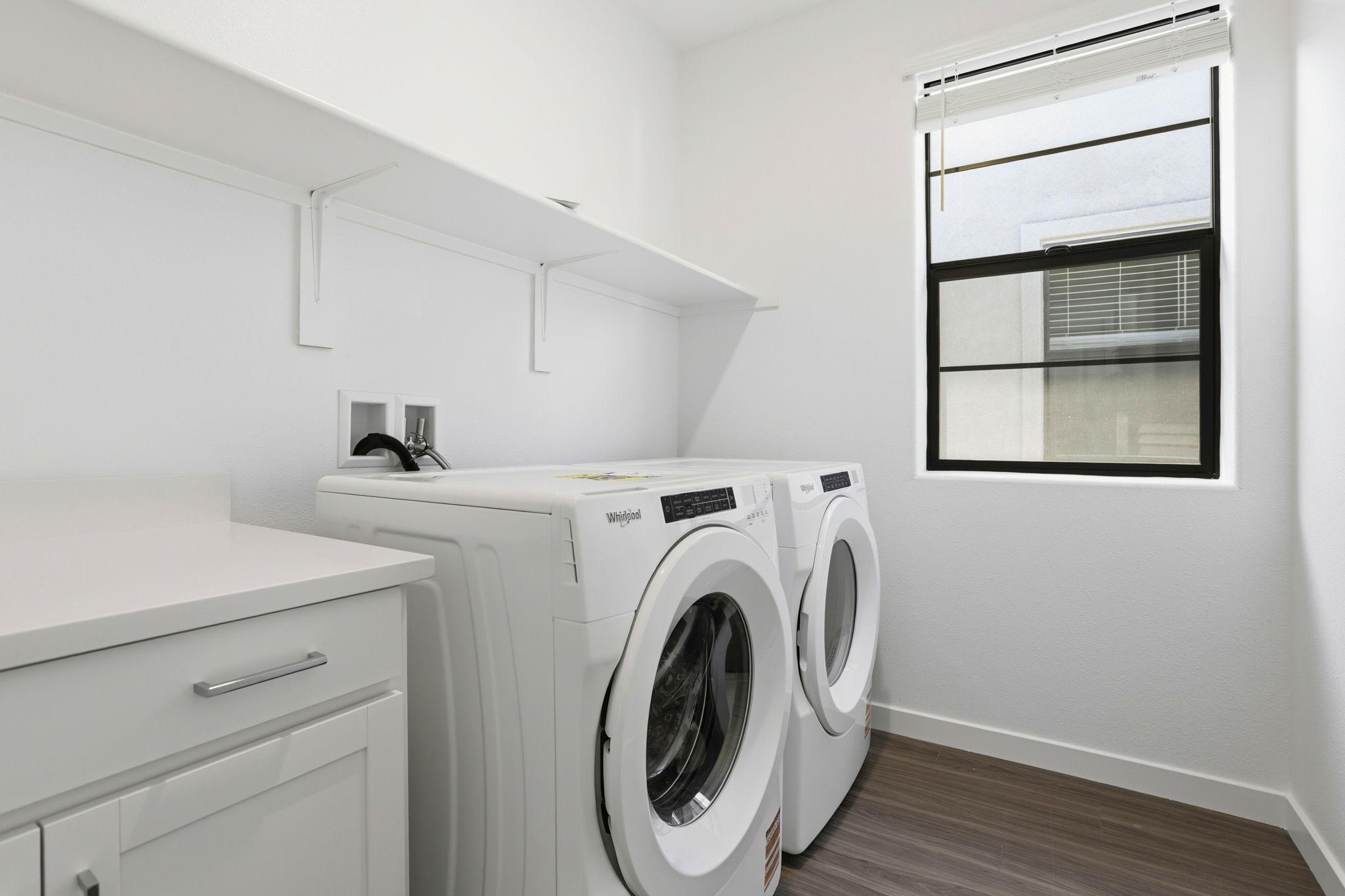A white laundry room with a washer and dryer.