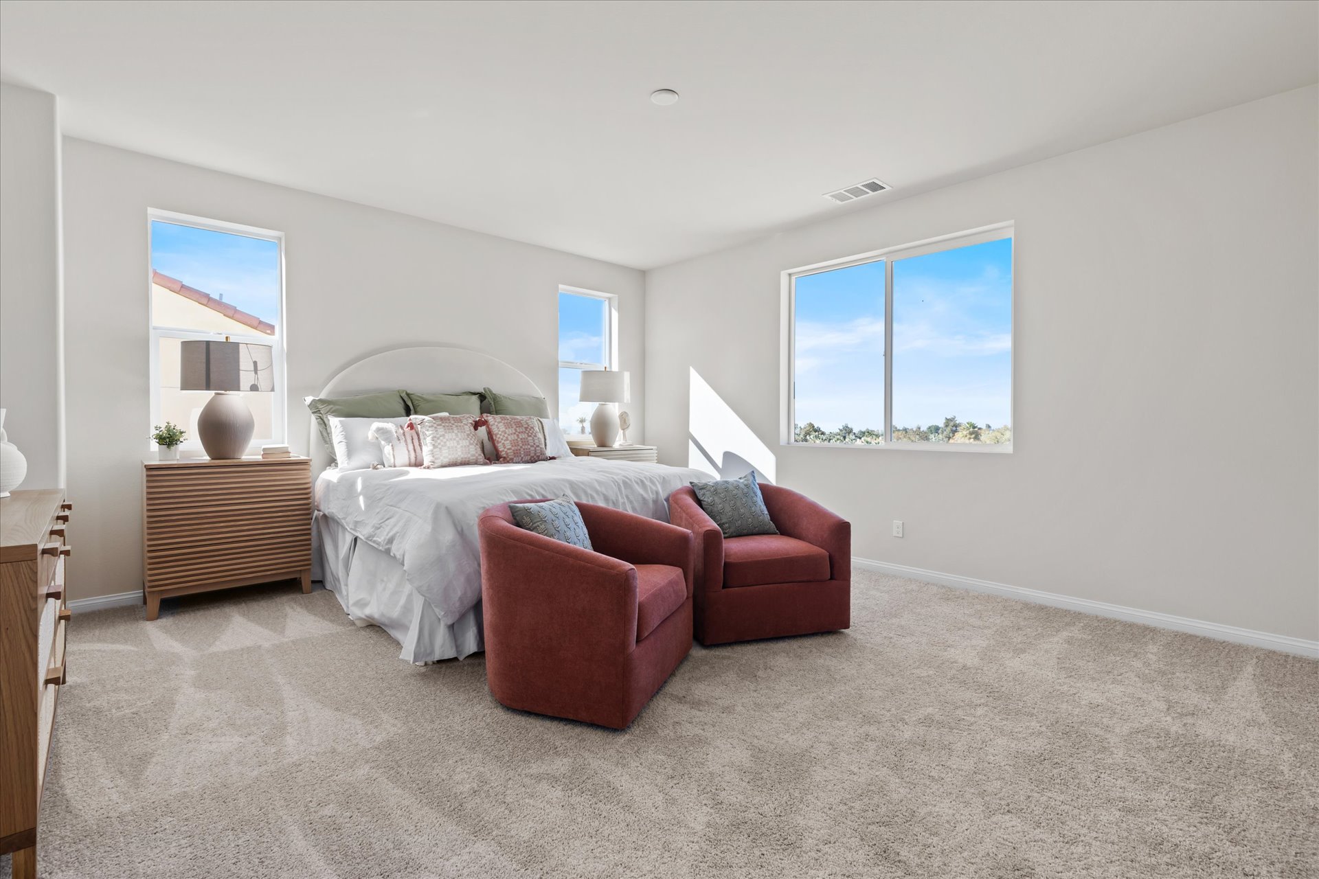 A bedroom with a bed and chairs.