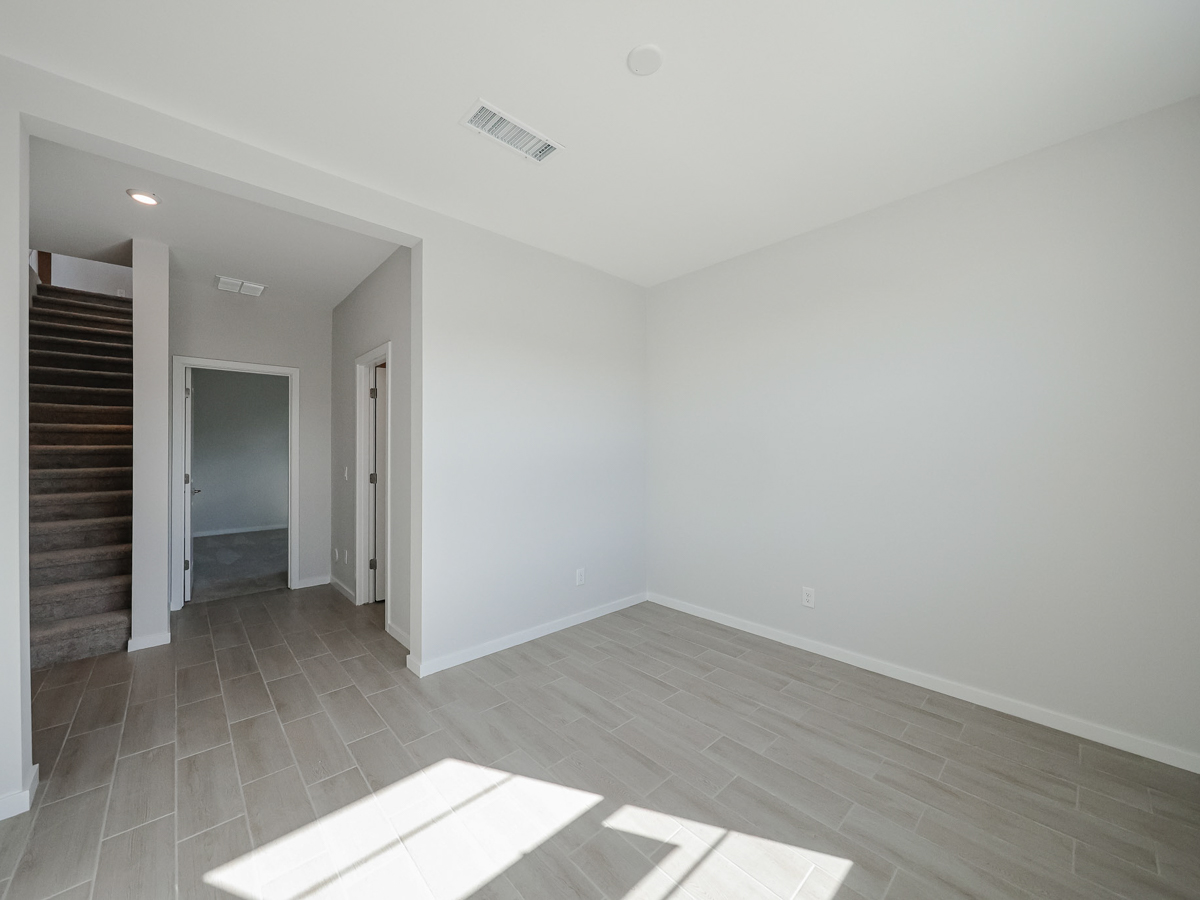 A room with a wood floor and a tile floor.