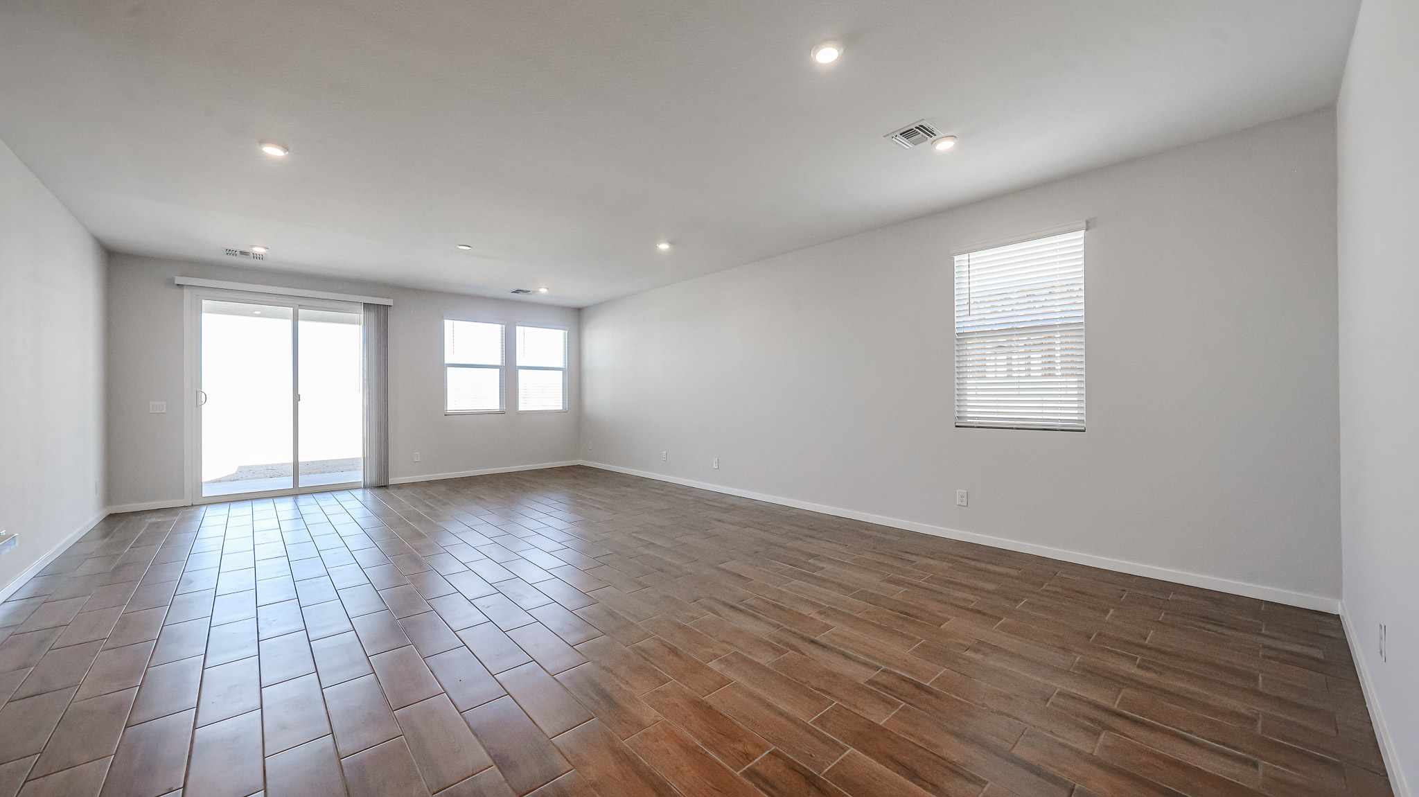 A room with a wood floor and windows.