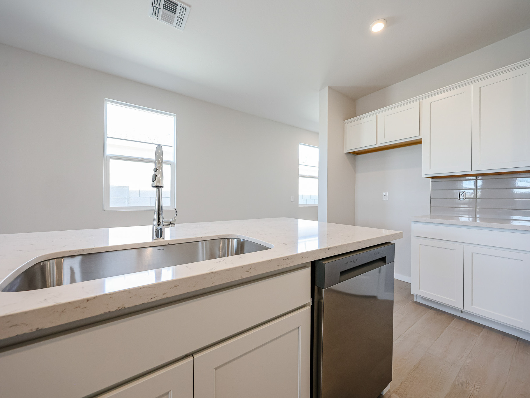 A kitchen with white cabinets.