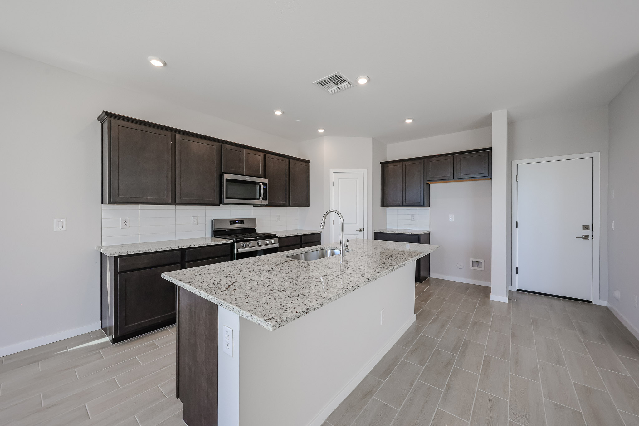 A kitchen with a marble counter top.