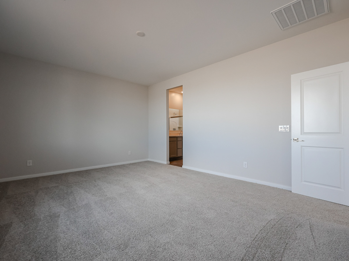 A room with white walls and a wood shelf with a door.