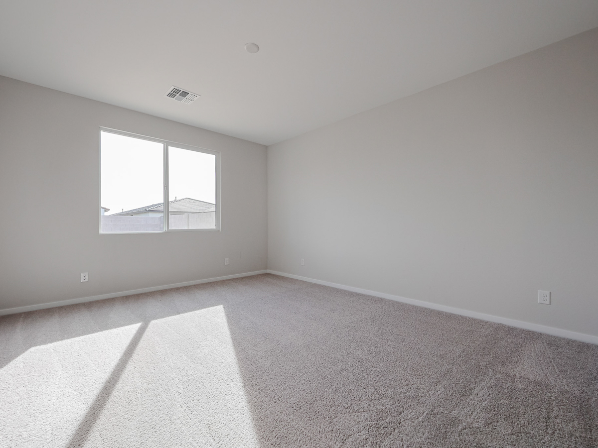A room with a window and carpet.