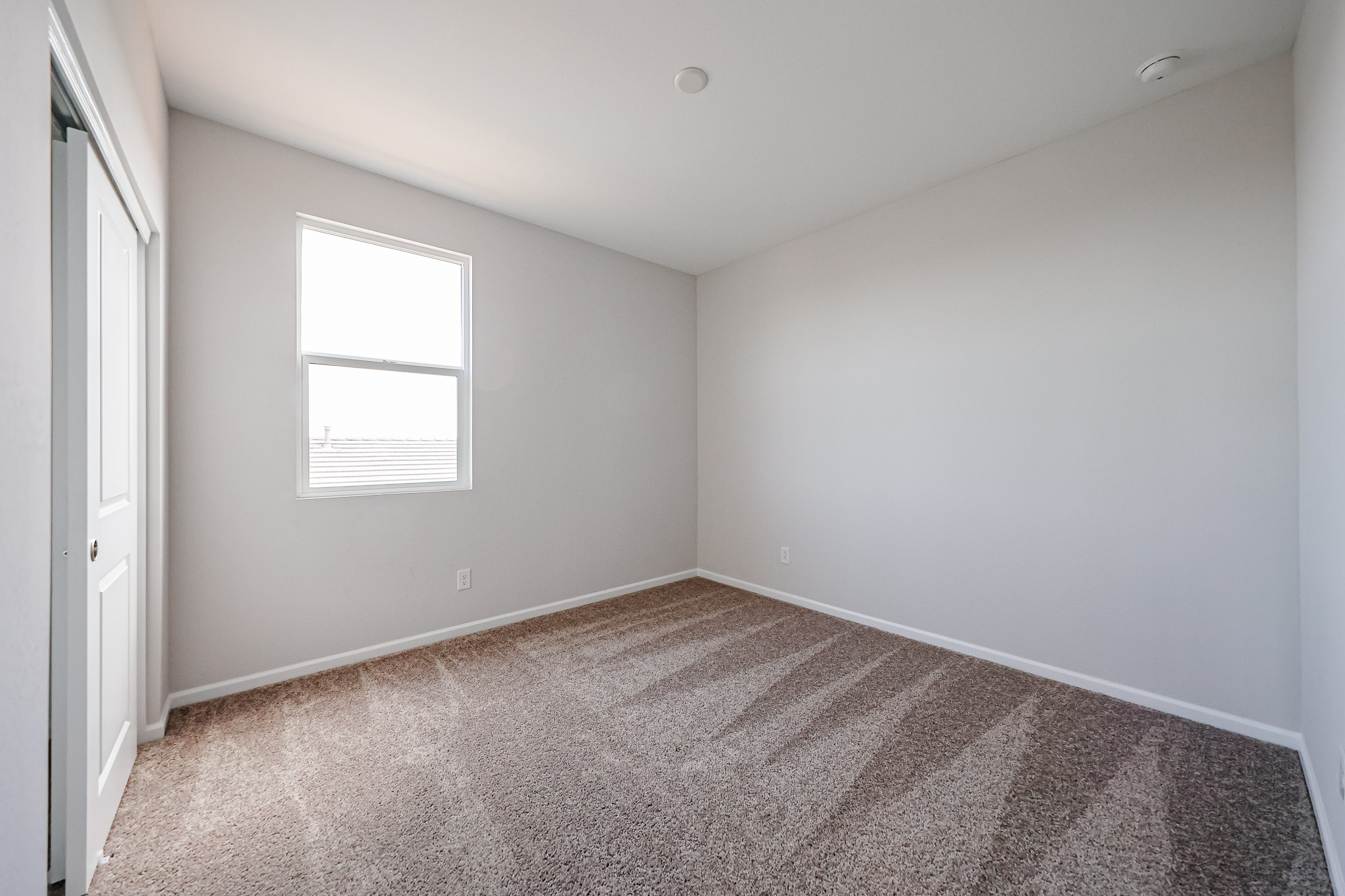 A room with a carpet and a window.