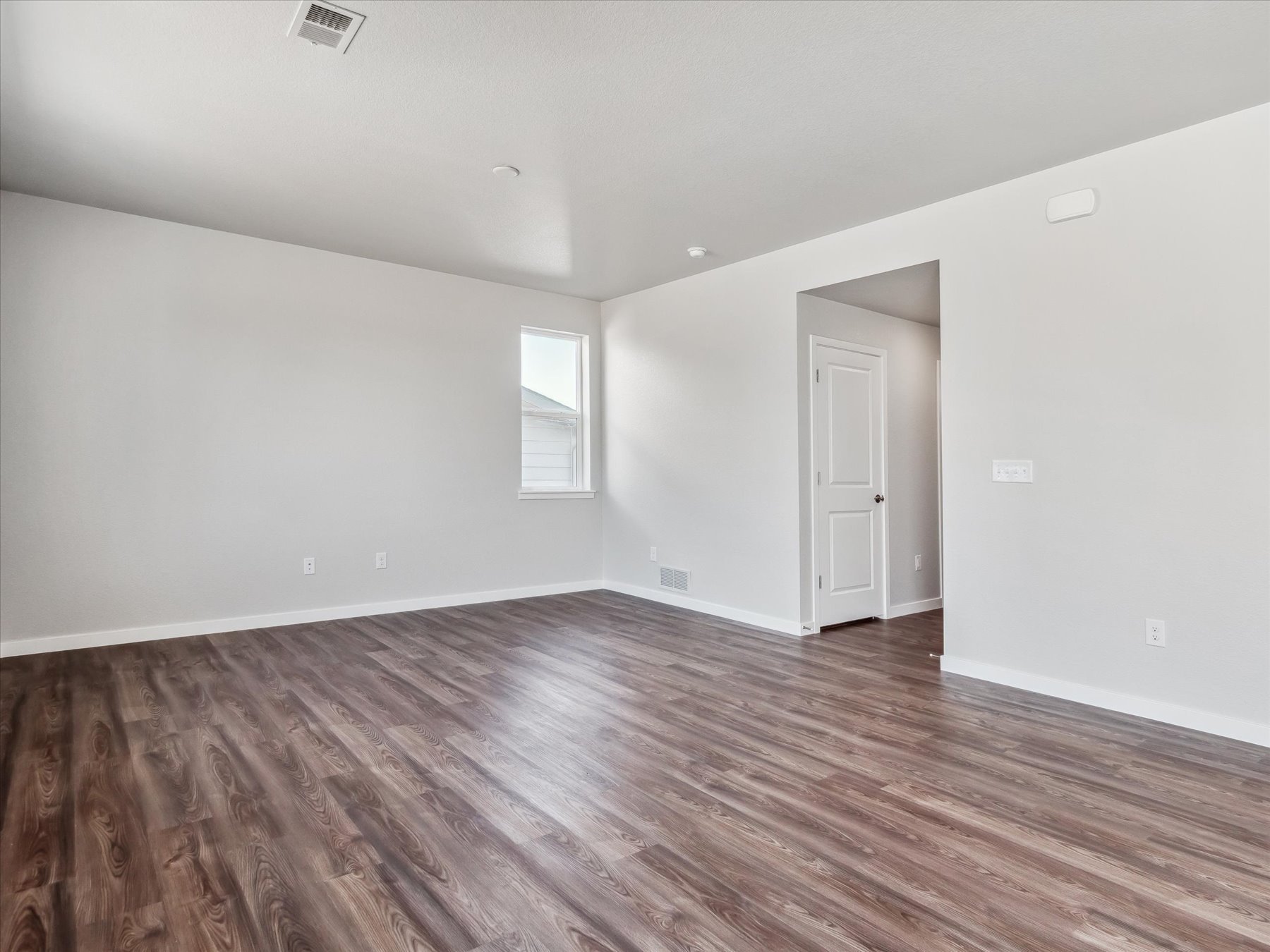 A room with a wood floor and a white door.