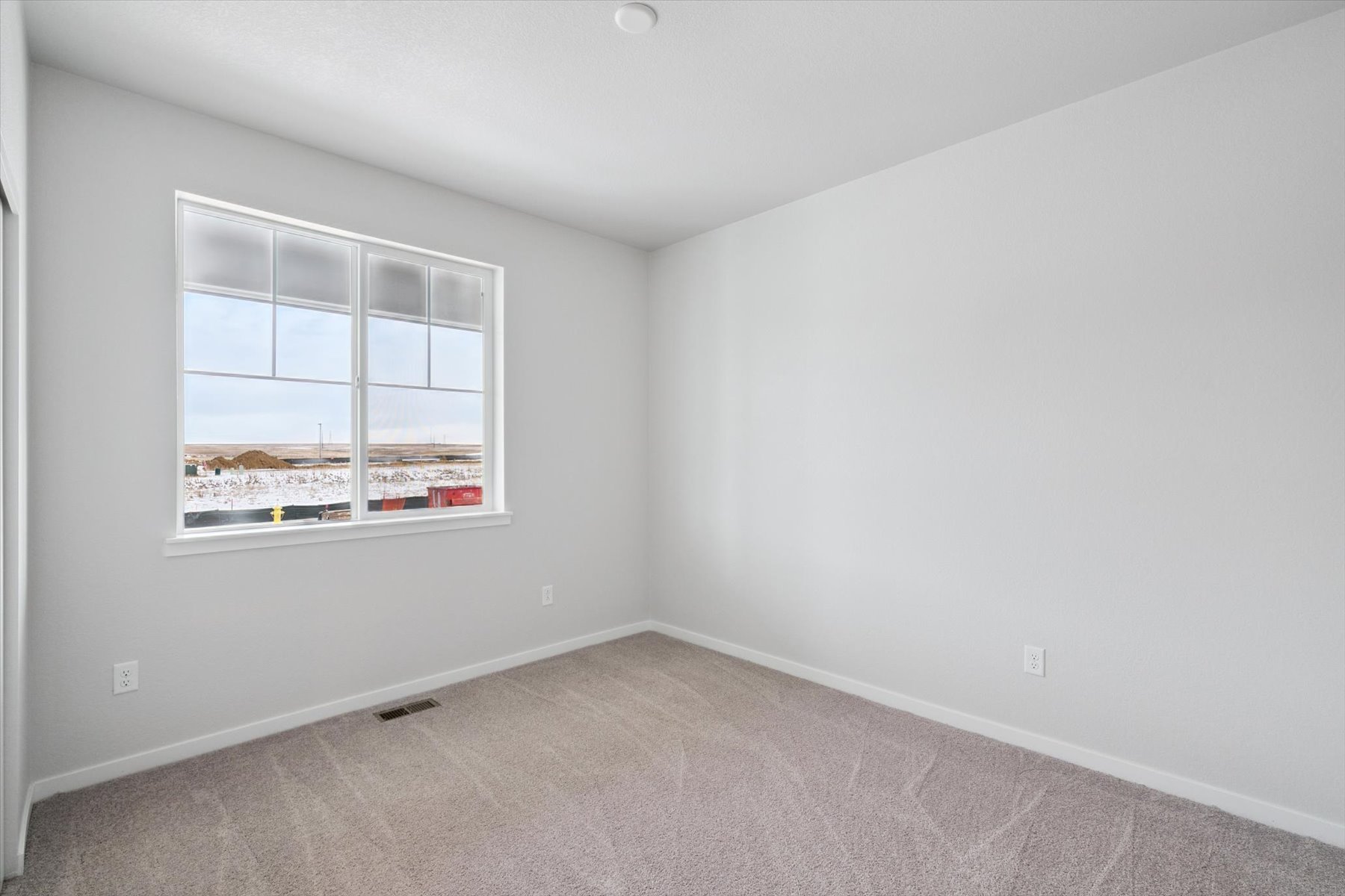 A room with a window and a carpet.