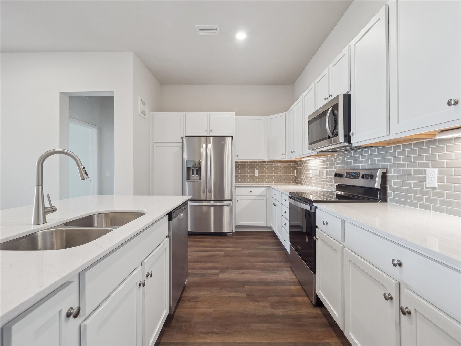 A kitchen with white cabinets.