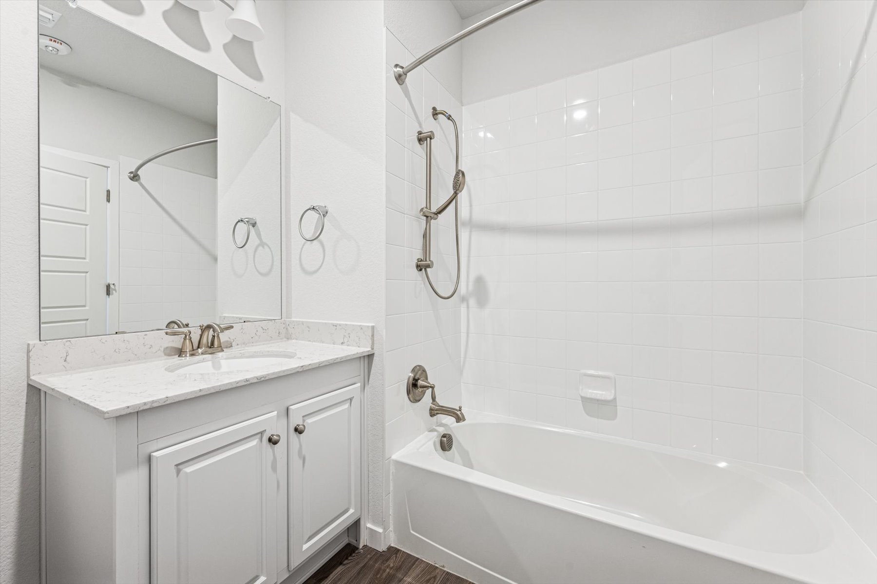 A bathroom with a tub sink and mirror.
