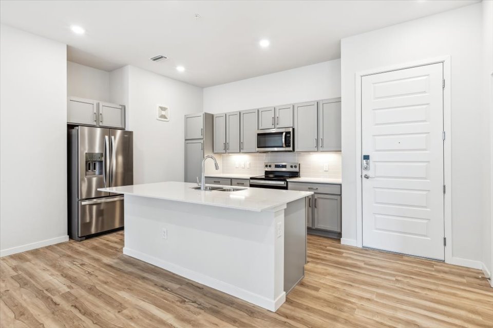 A kitchen with white cabinets.
