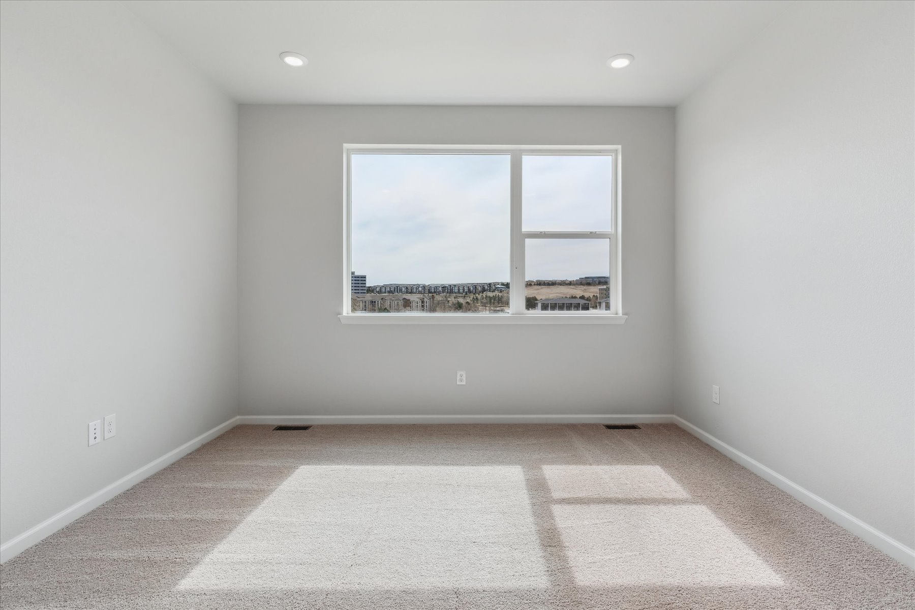 A room with a window and a view of a city.