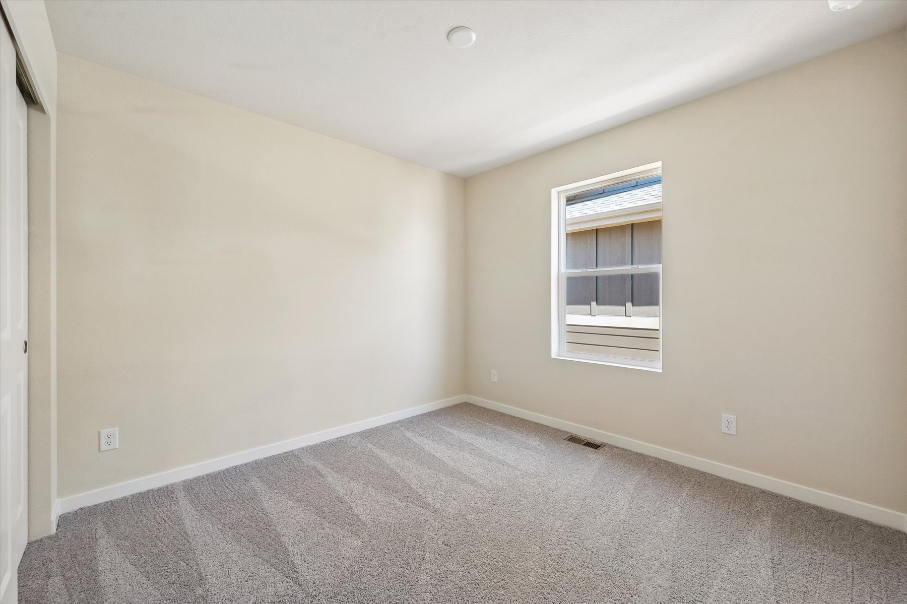 A room with a carpet and a window.