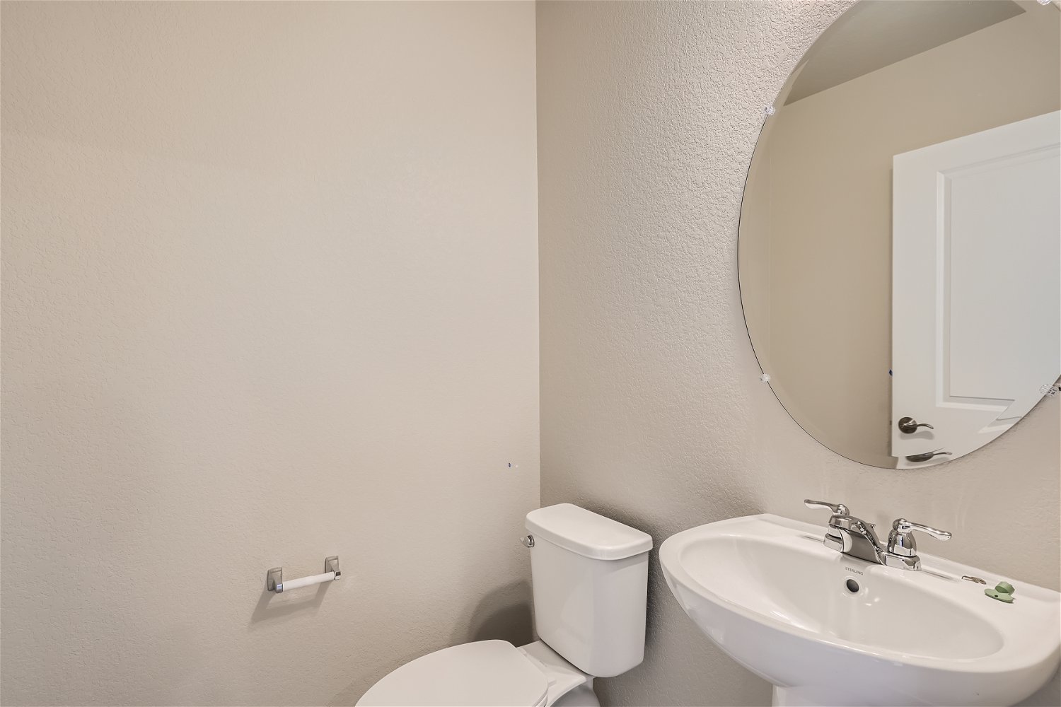 A bathroom with a round mirror.