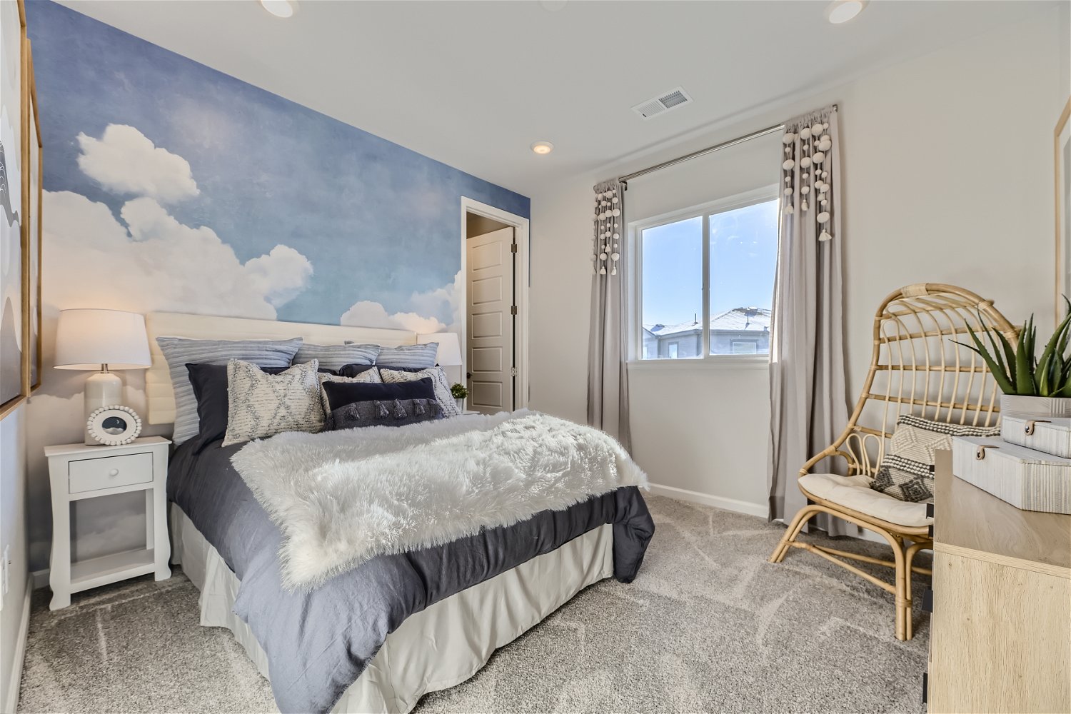 A bedroom with a bed and a chair.