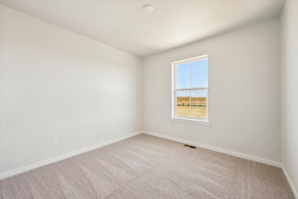 A room with a window and carpet.