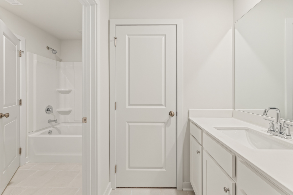 A bathroom with white cabinets.
