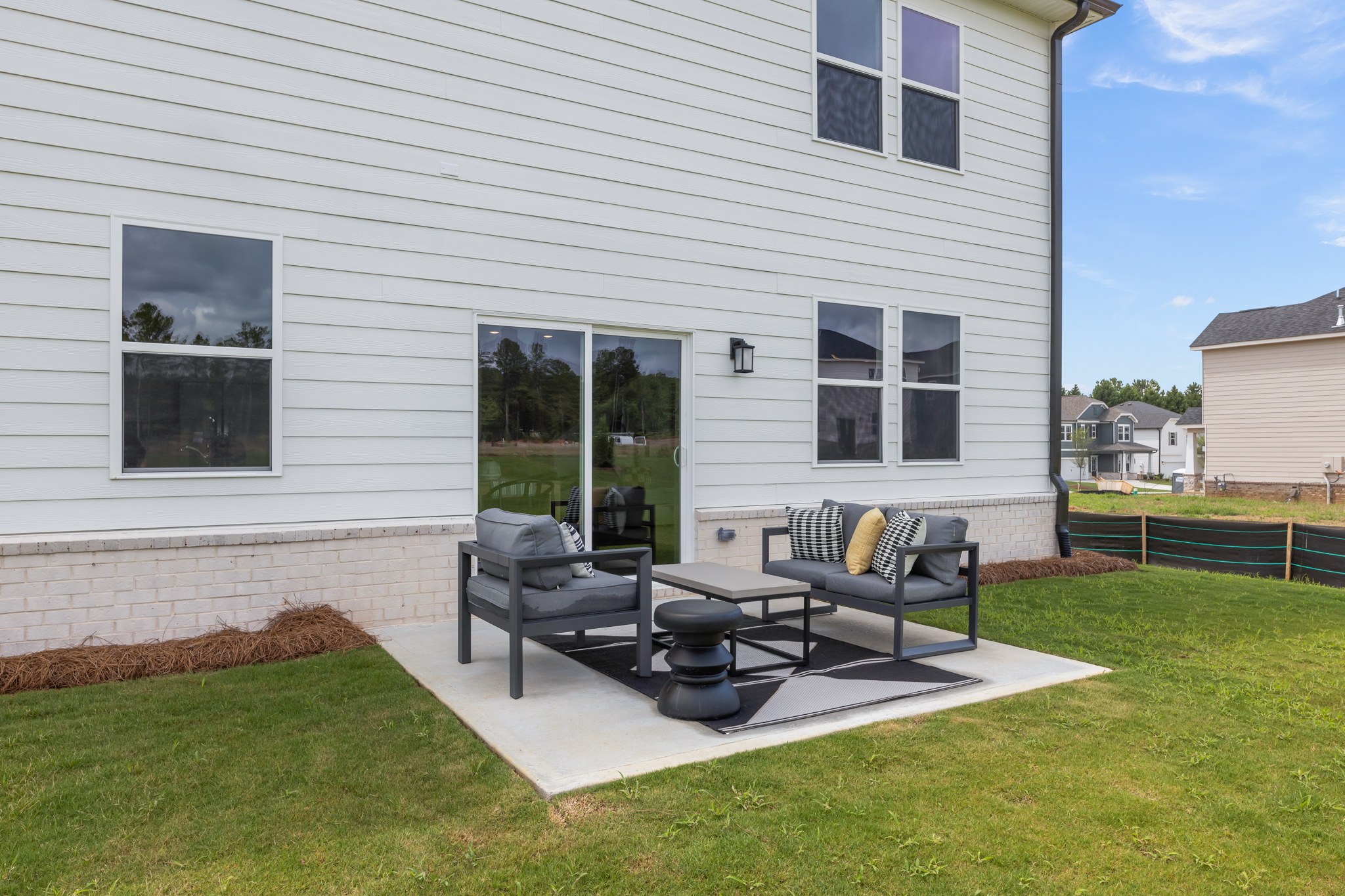 A house with a patio and a table and chairs in the front.