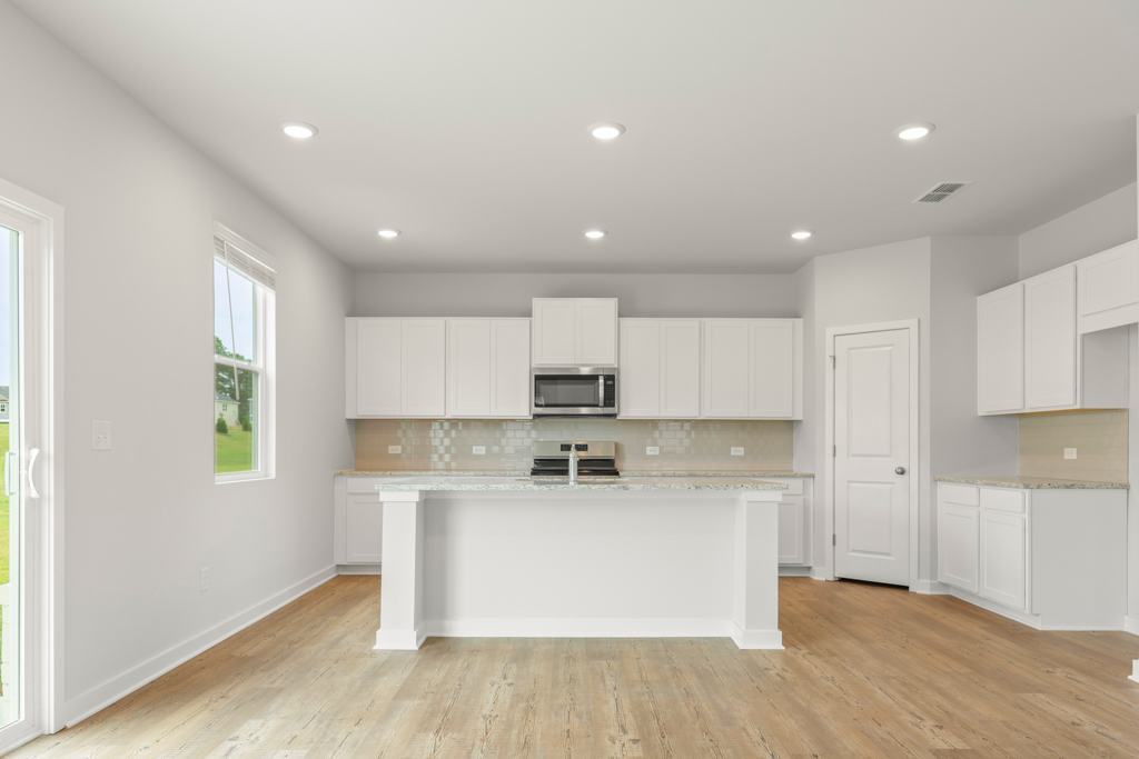 A kitchen with white cabinets.