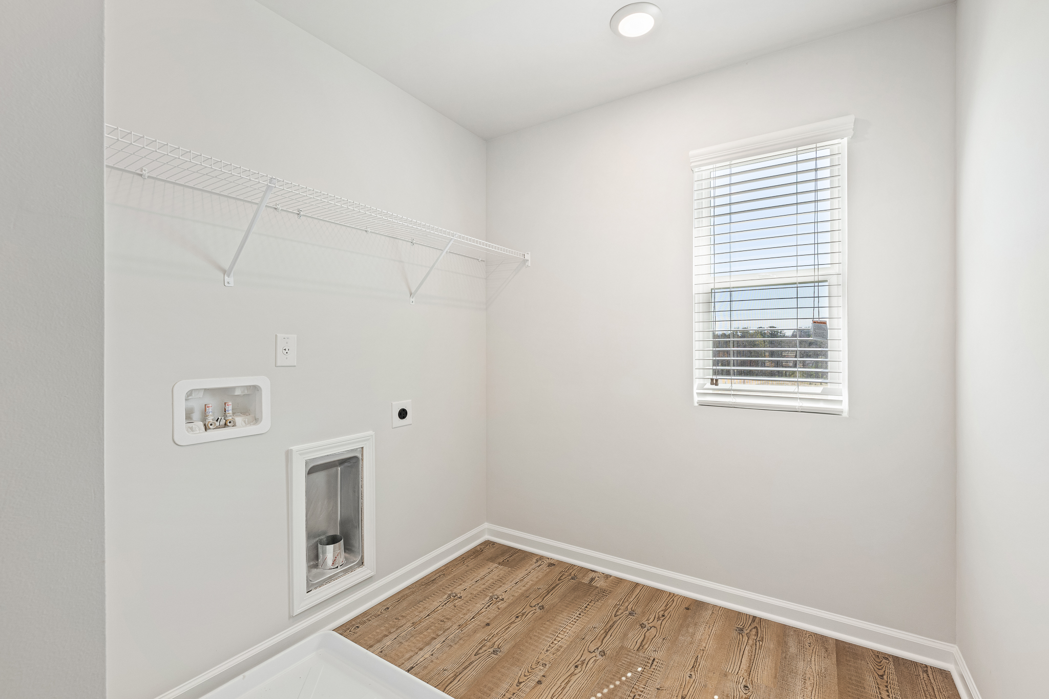 A room with a wood floor and a window.