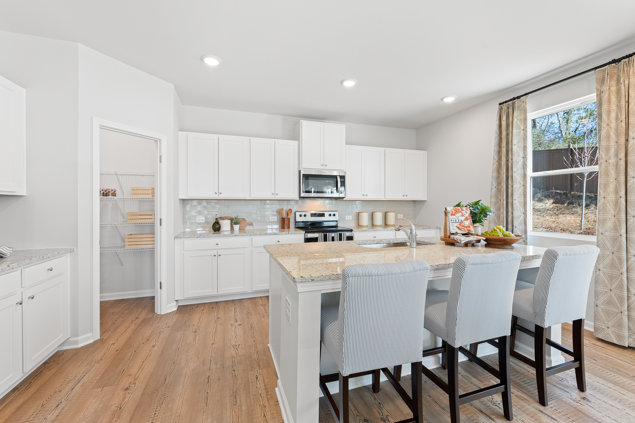 A kitchen with white cabinets.