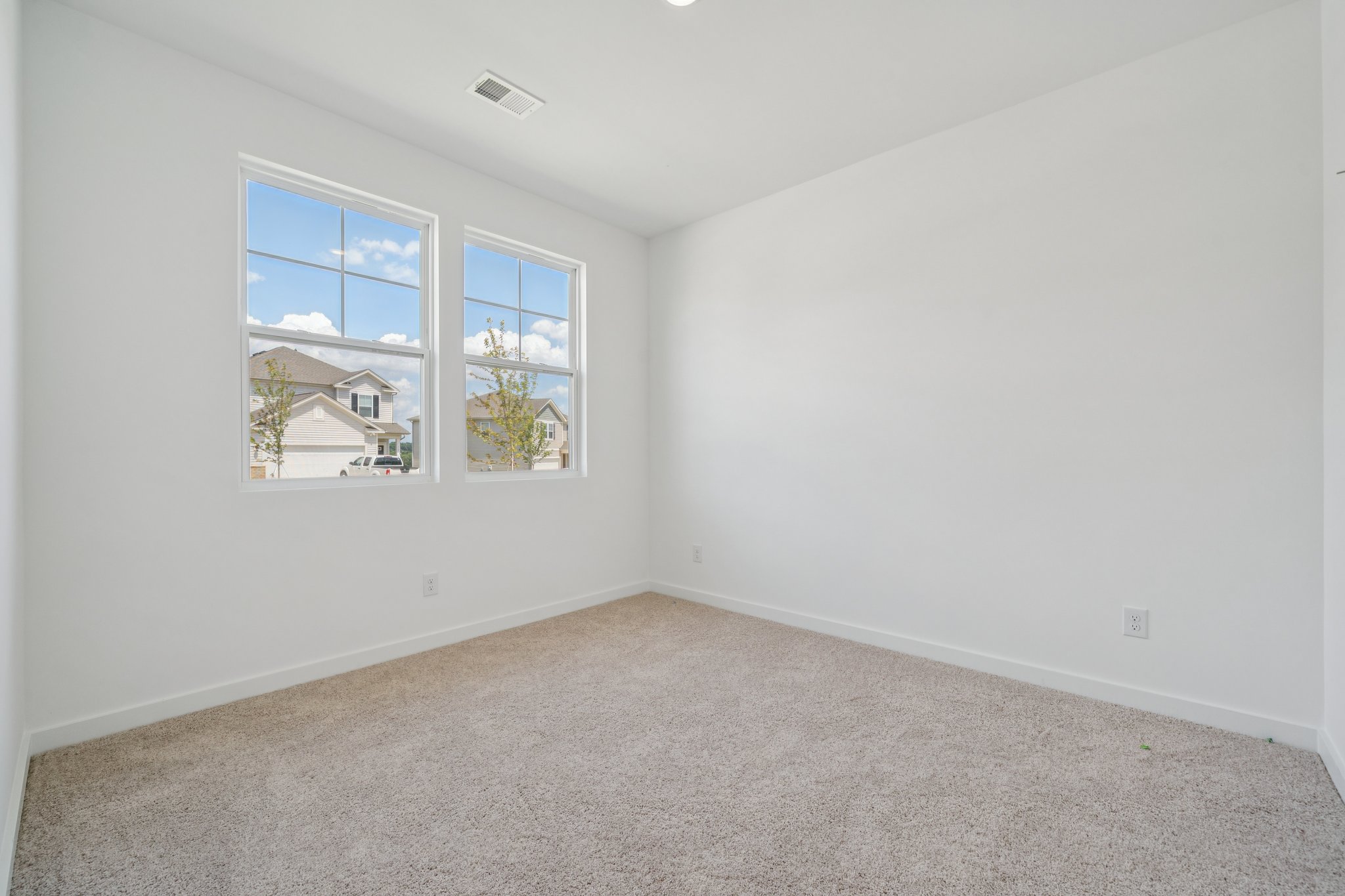 A room with a window and a carpet.