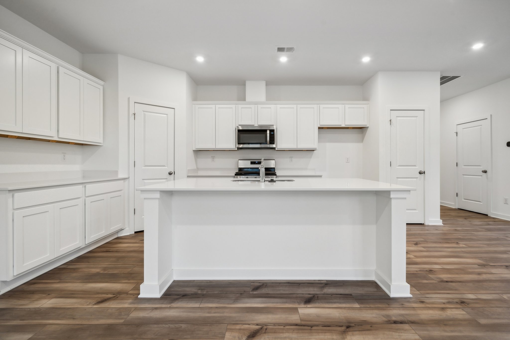 A kitchen with white cabinets.