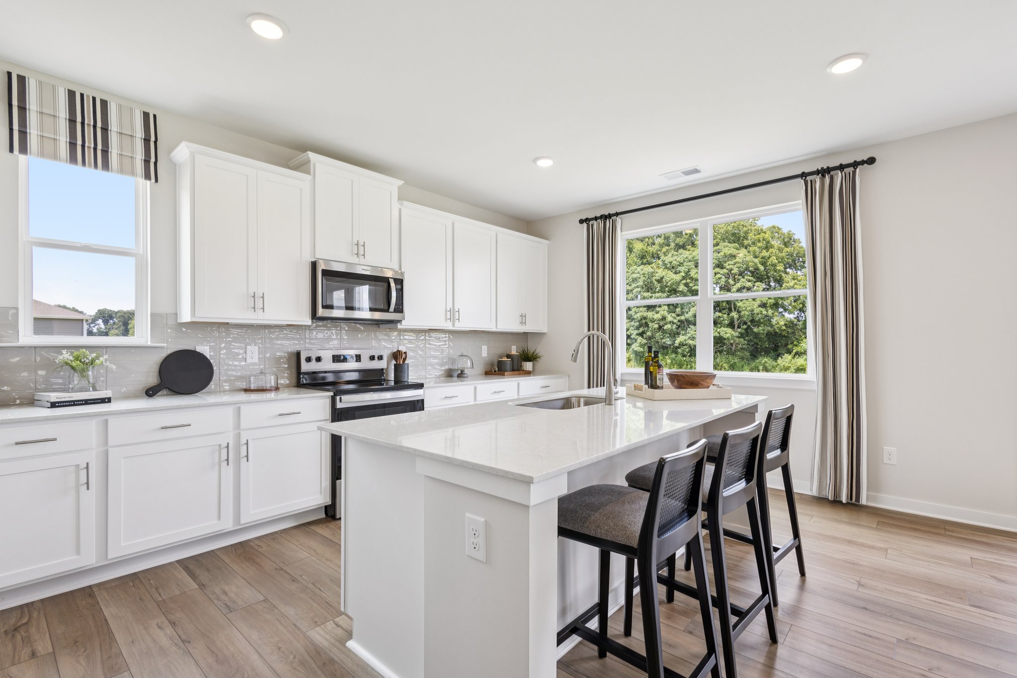 A kitchen with white cabinets.