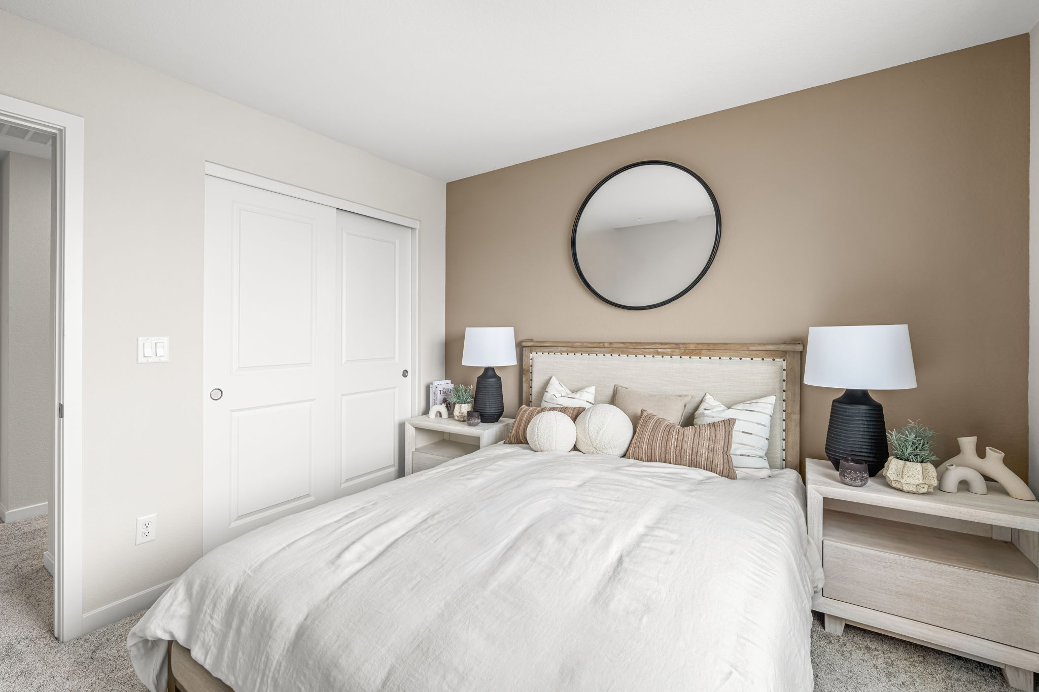 A bedroom with a large mirror.