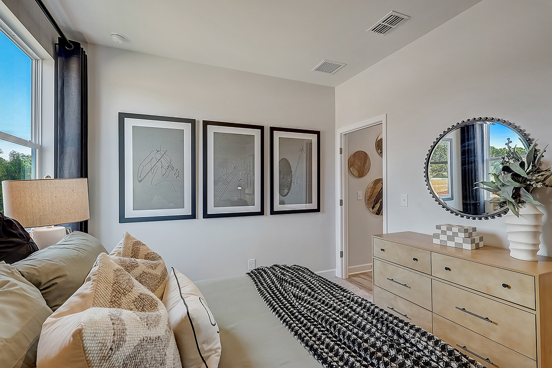 A bedroom with a bed and a mirror.