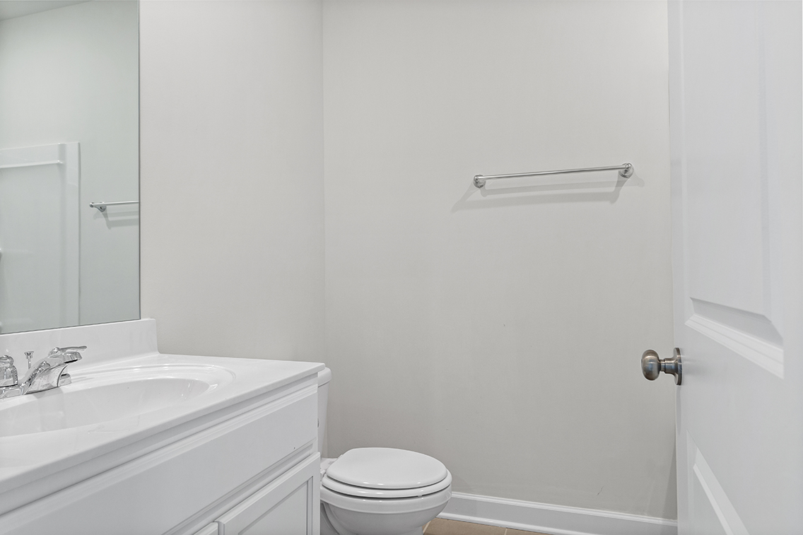 A bathroom with a toilet sink and mirror.