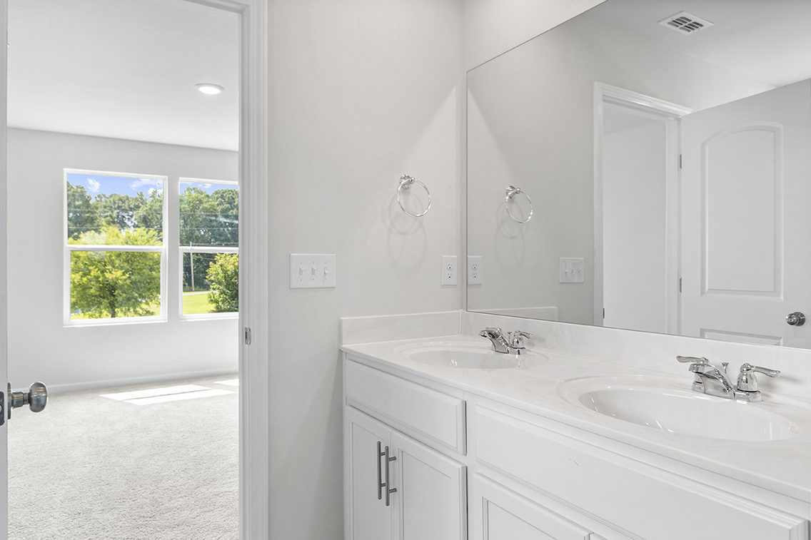 A bathroom with white cabinets.