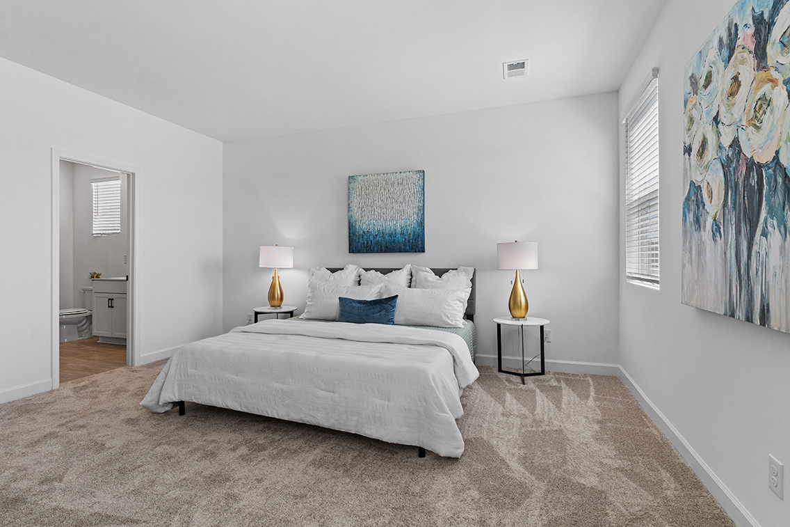 A bedroom with a bed and lamps.