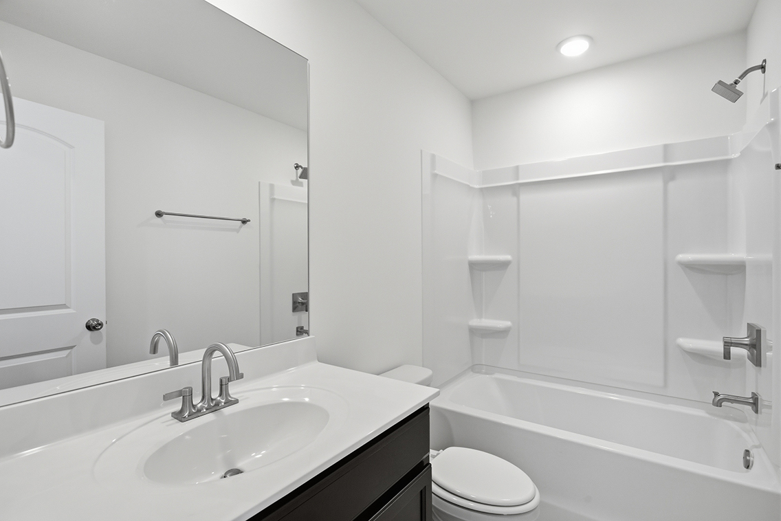 A bathroom with a tub sink and toilet.