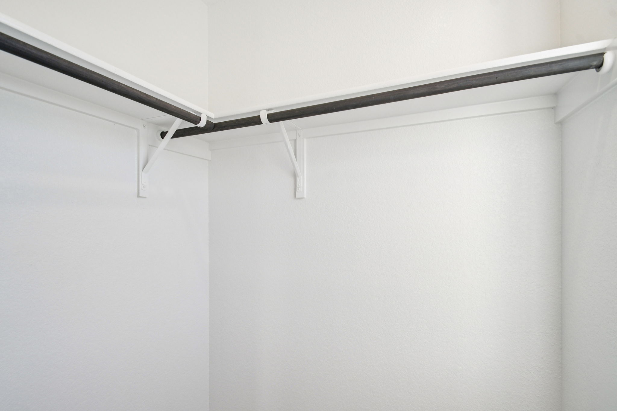 A white wall with a metal bar.