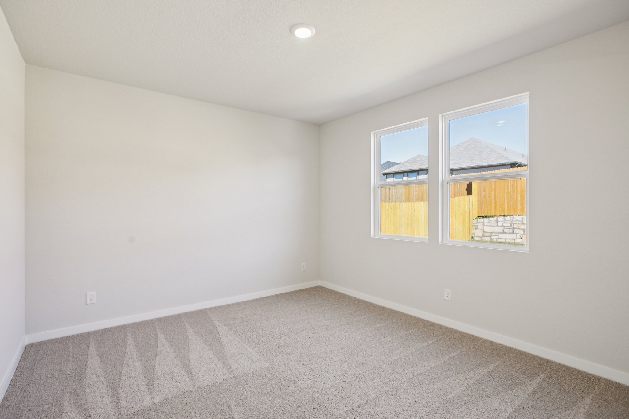 A room with a window and a carpet.