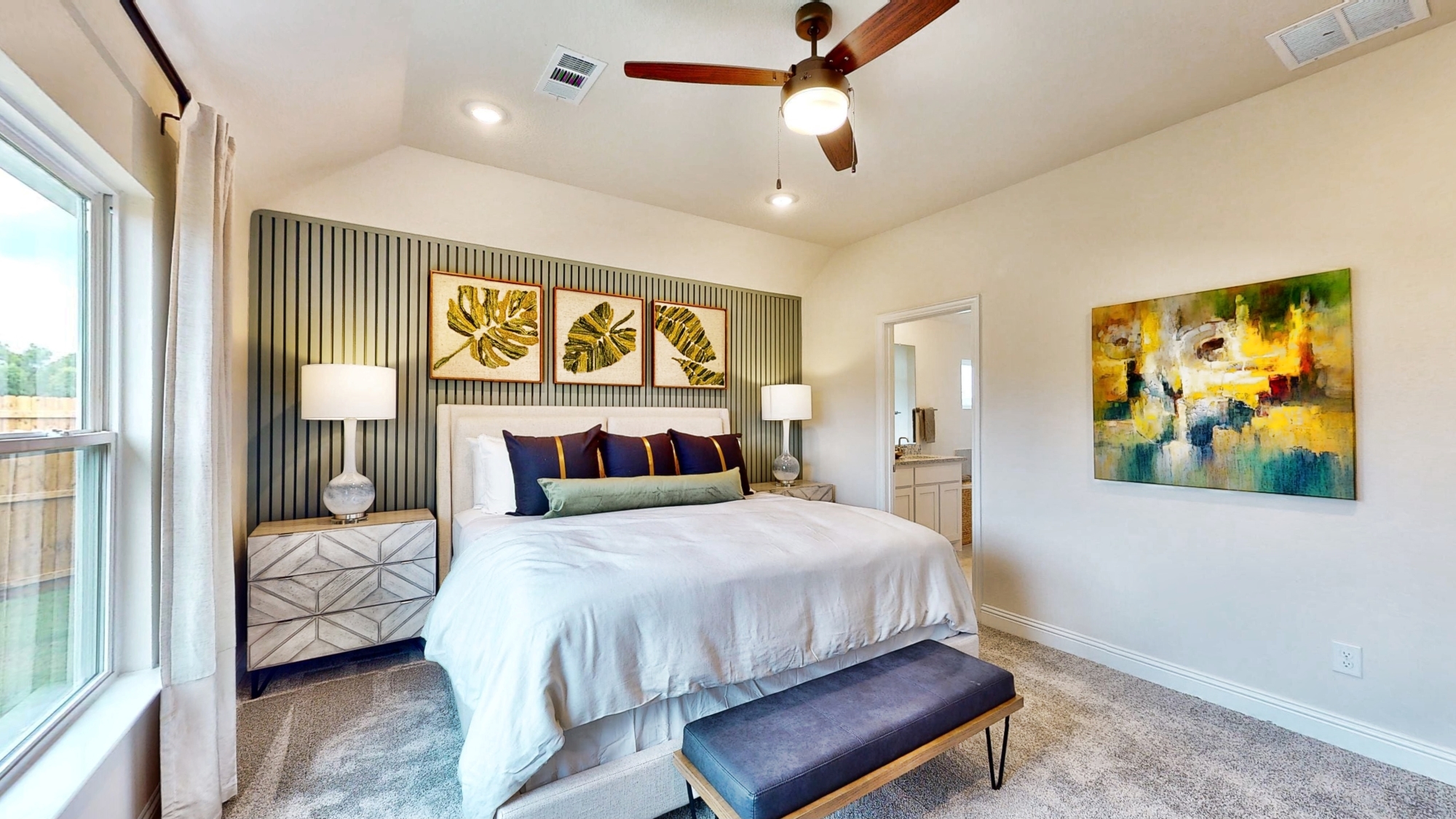 A bedroom with a large painting on the wall.
