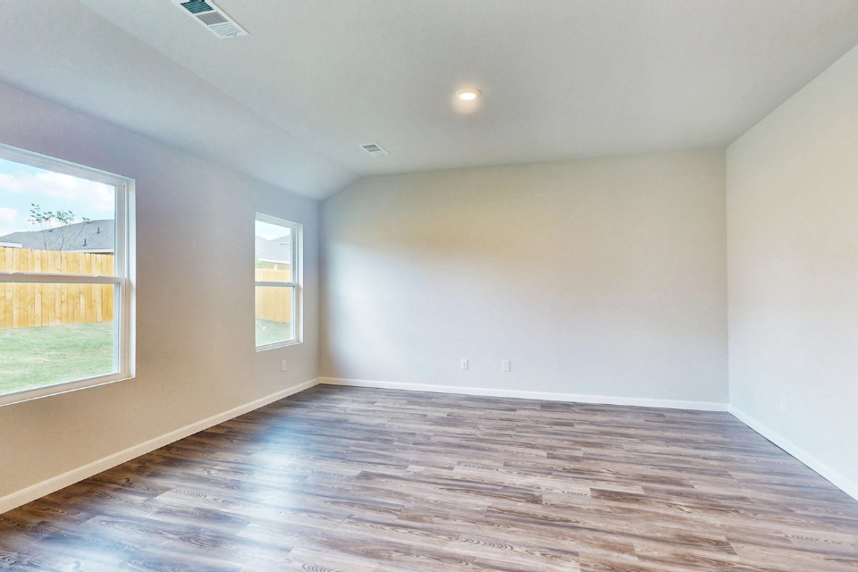 A room with a wood floor and windows.