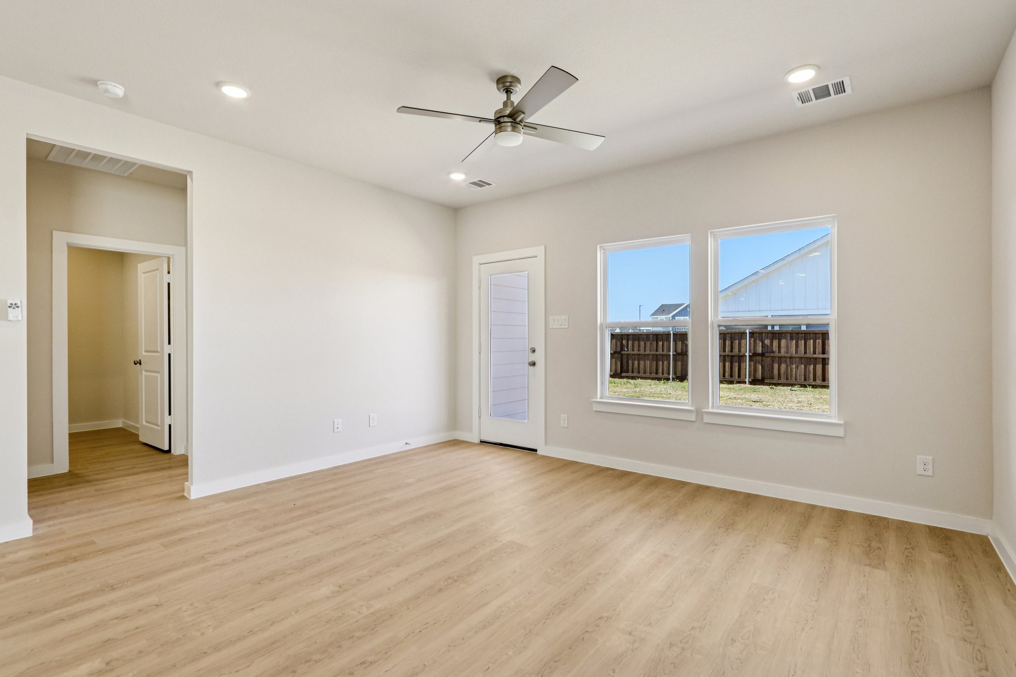 A room with a wood floor and a ceiling fan.