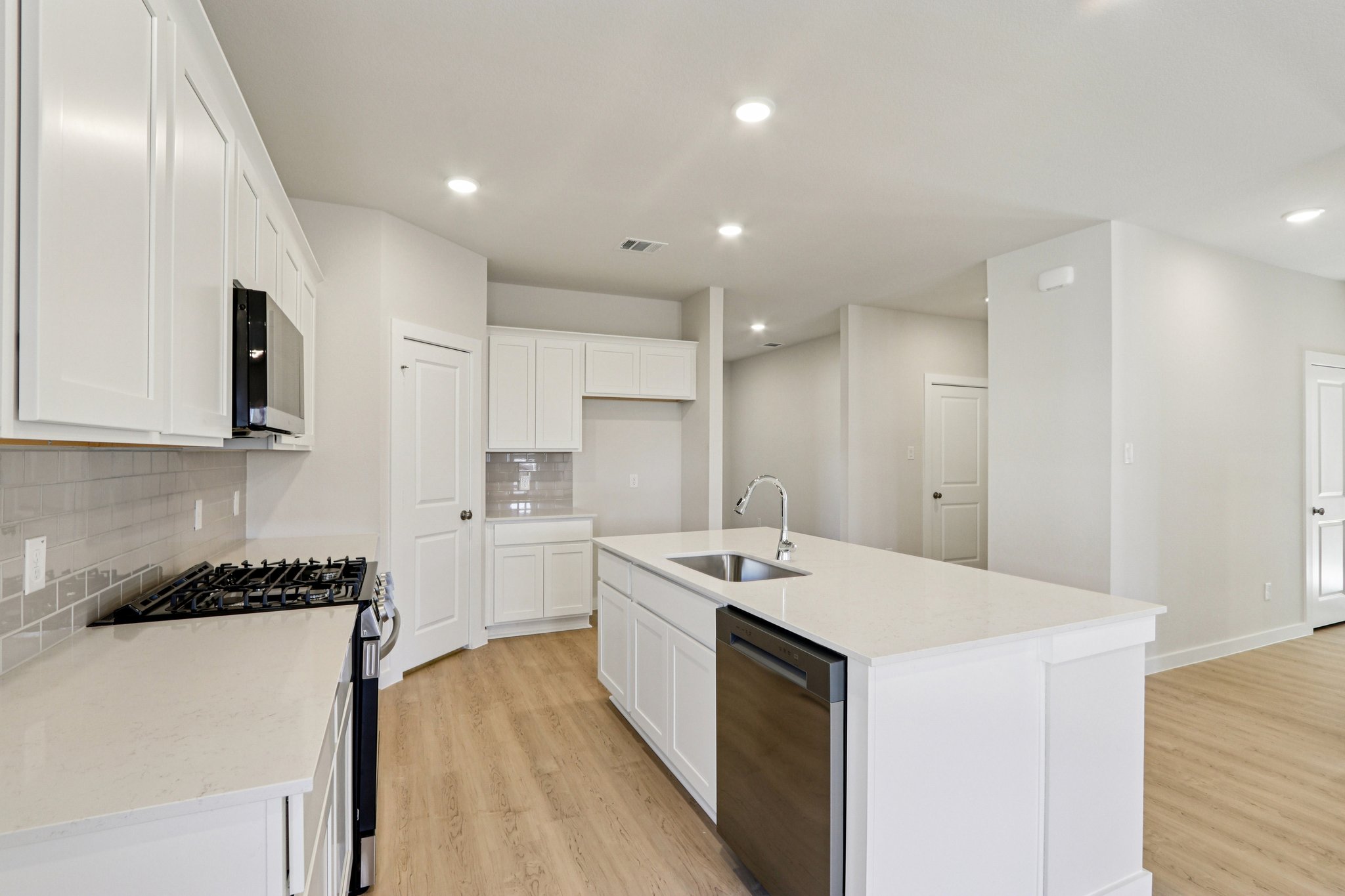 A kitchen with white cabinets.