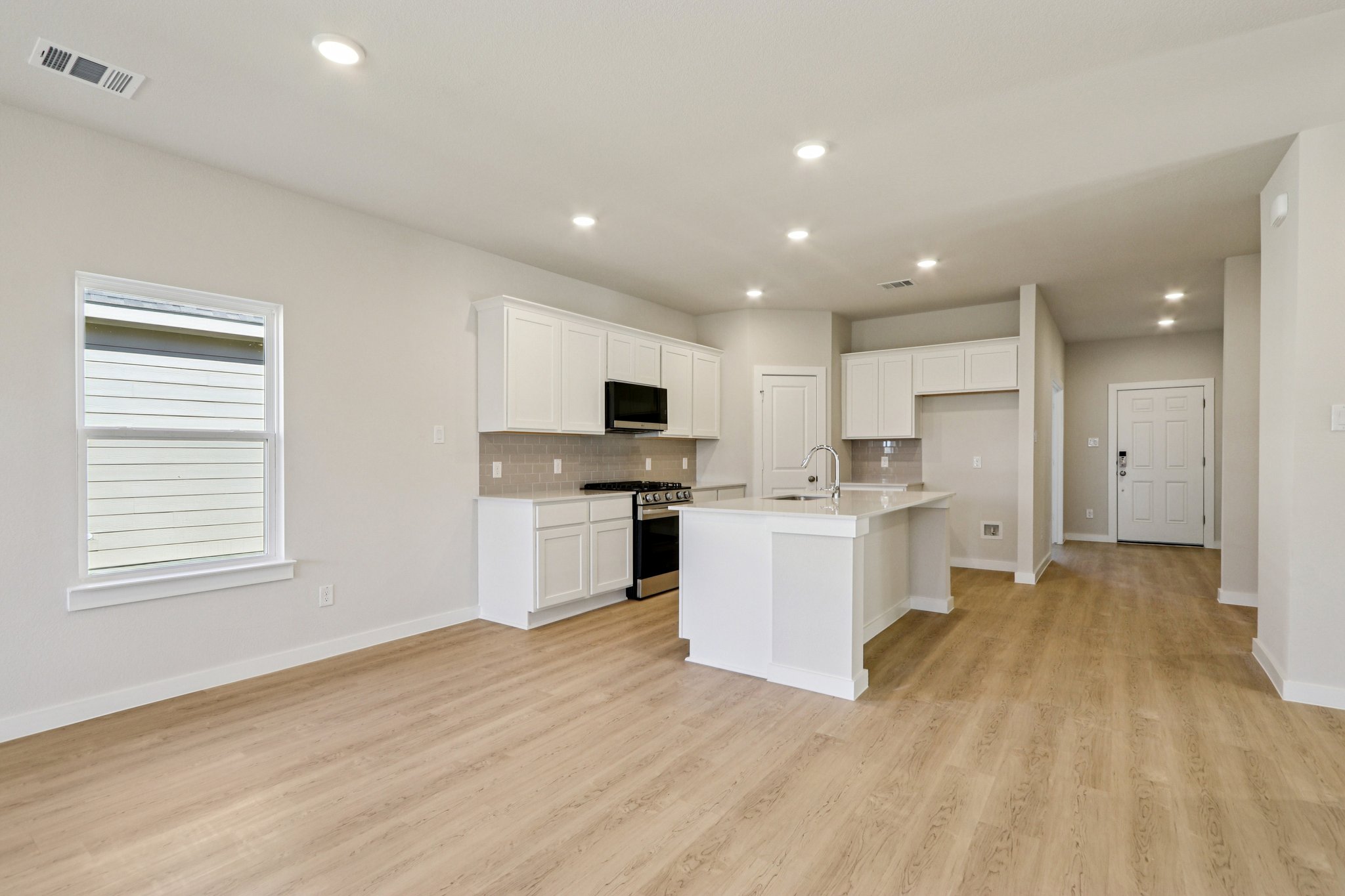A kitchen with white cabinets.
