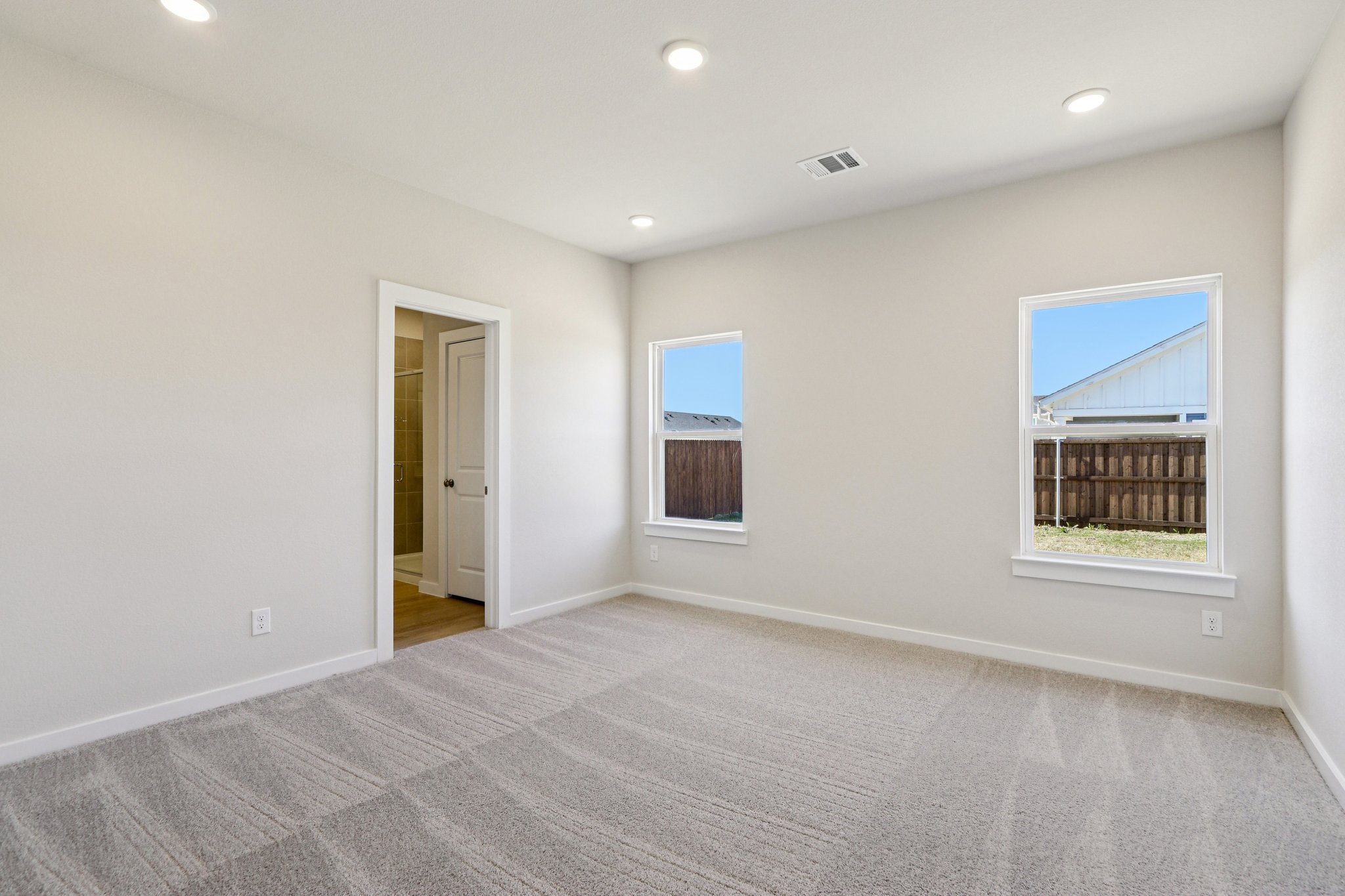 A room with a carpet and windows.