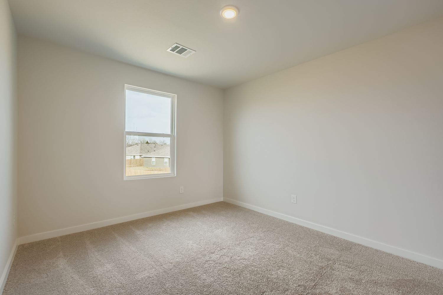 A room with a window and a carpet.