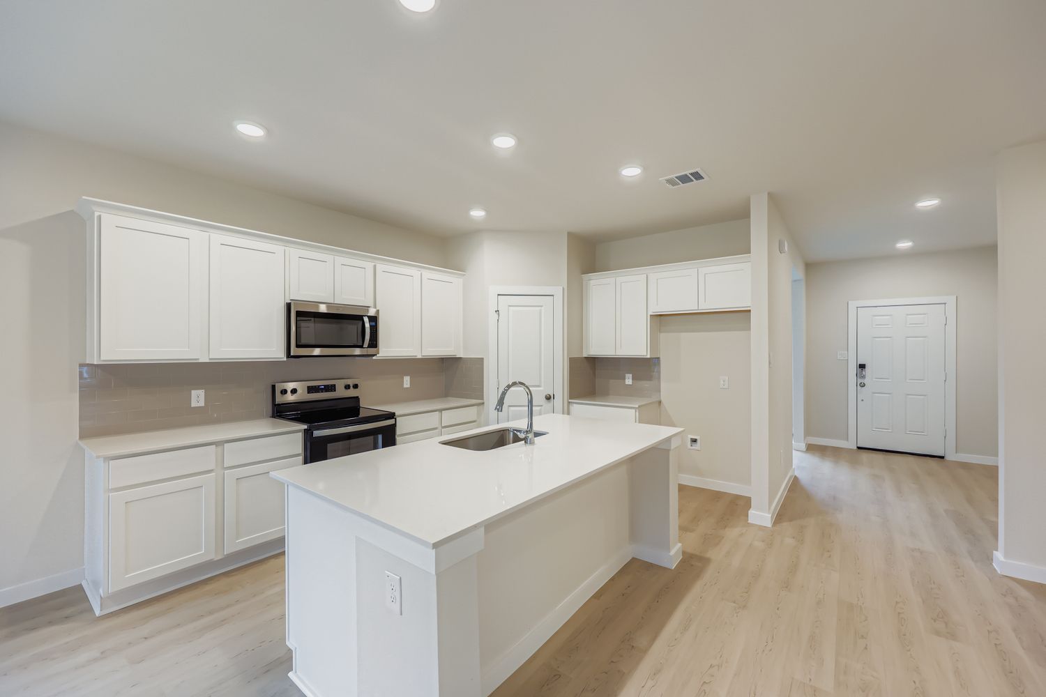 A kitchen with white cabinets.