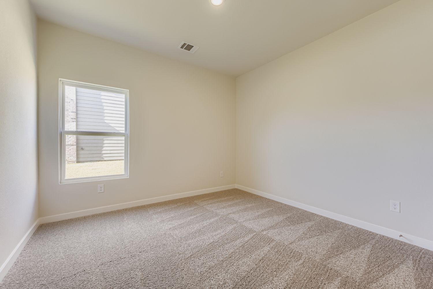 A room with a carpet and a window.