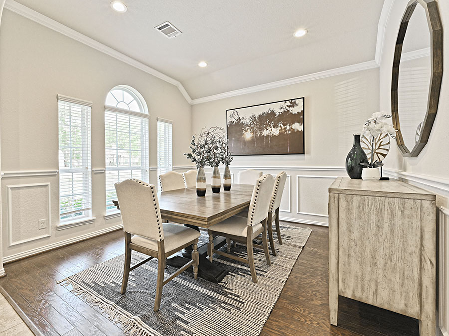 A dining room with a table and chairs.