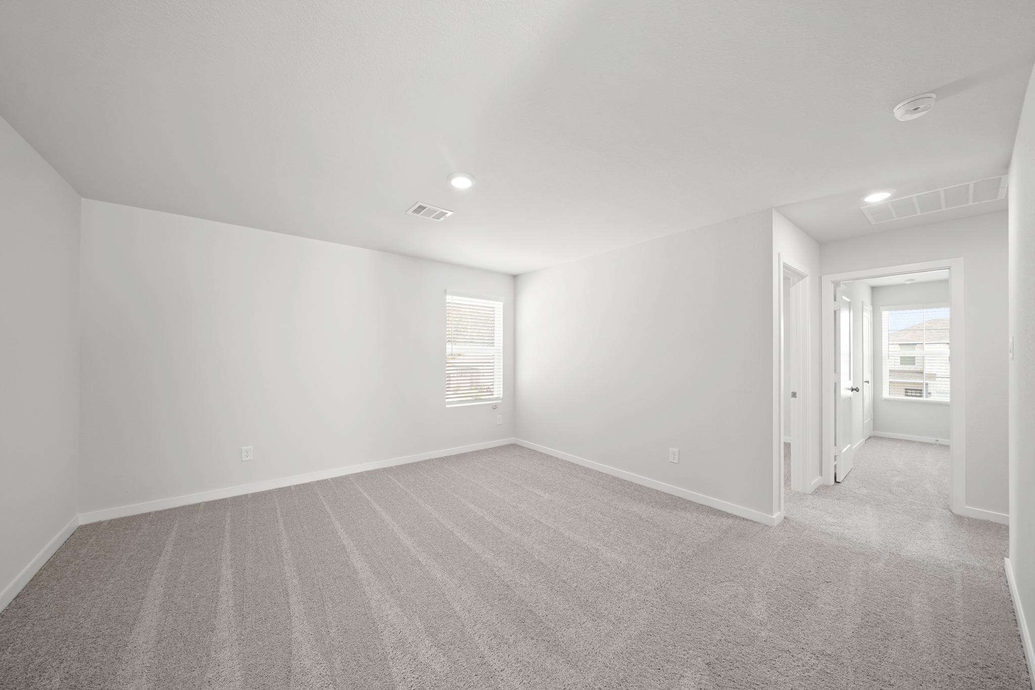 A room with a carpet and a door.