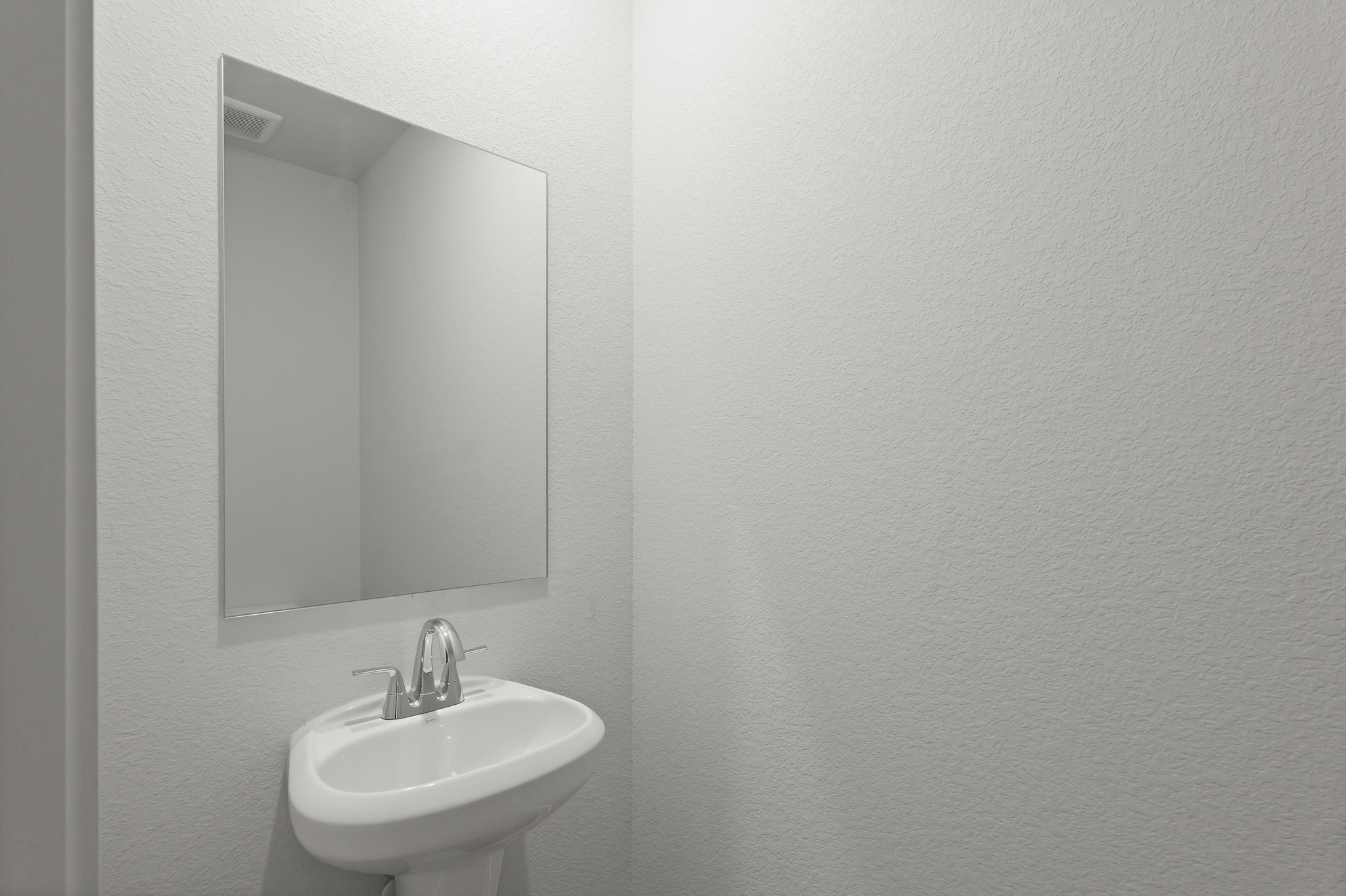 A bathroom with a round mirror.